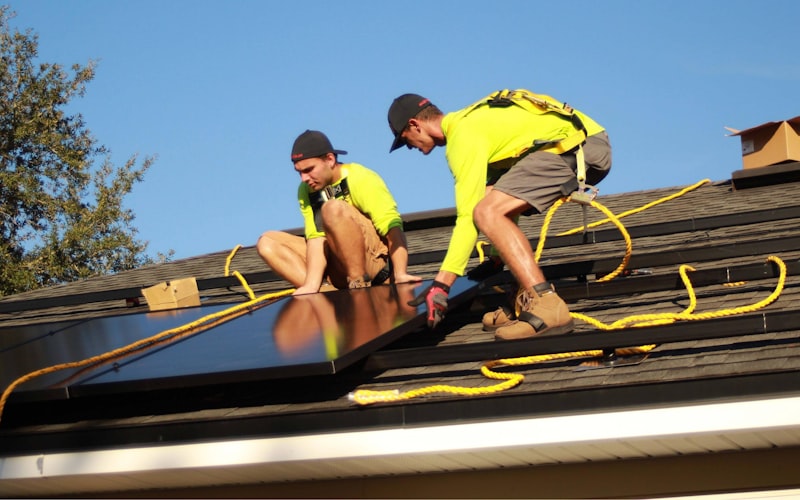 Professional roofers installing shingles on a residential roof