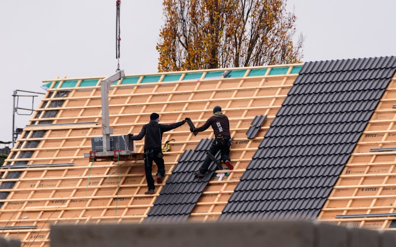 Professional roofing crew installing tiles on residential roof